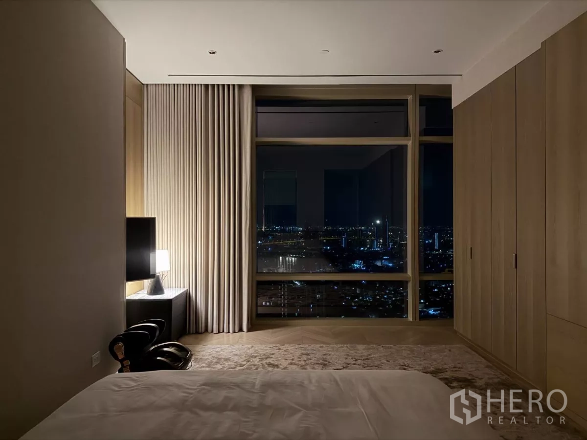 คอนโด ให้เช่าในSathon, Bangkok - ห้องนอนยามค่ำคืน มองเห็นแสงไฟเมืองผ่านหน้าต่างบานใหญ่ พร้อมตู้บิวท์อิน