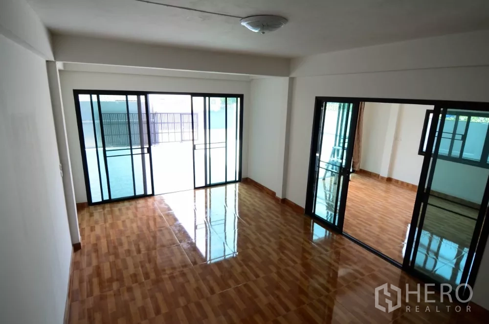 สำนักงานที่บ้าน ให้เช่าในLat Phrao, Bangkok - พื้นที่ชั้นล่างแบบเปิดโล่ง ปูพื้นลายไม้เงาและกั้นด้วยกระจกบานเลื่อนบานใหญ่