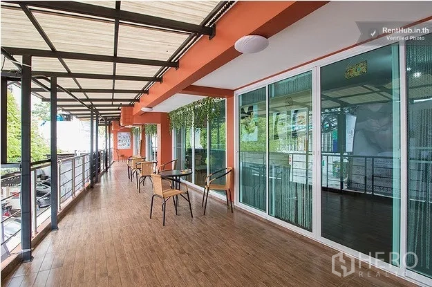 Office Space for rent in Khlong Toei, Bangkok - Covered outdoor terrace with tables, chairs and sliding glass entrances overlooking greenery.