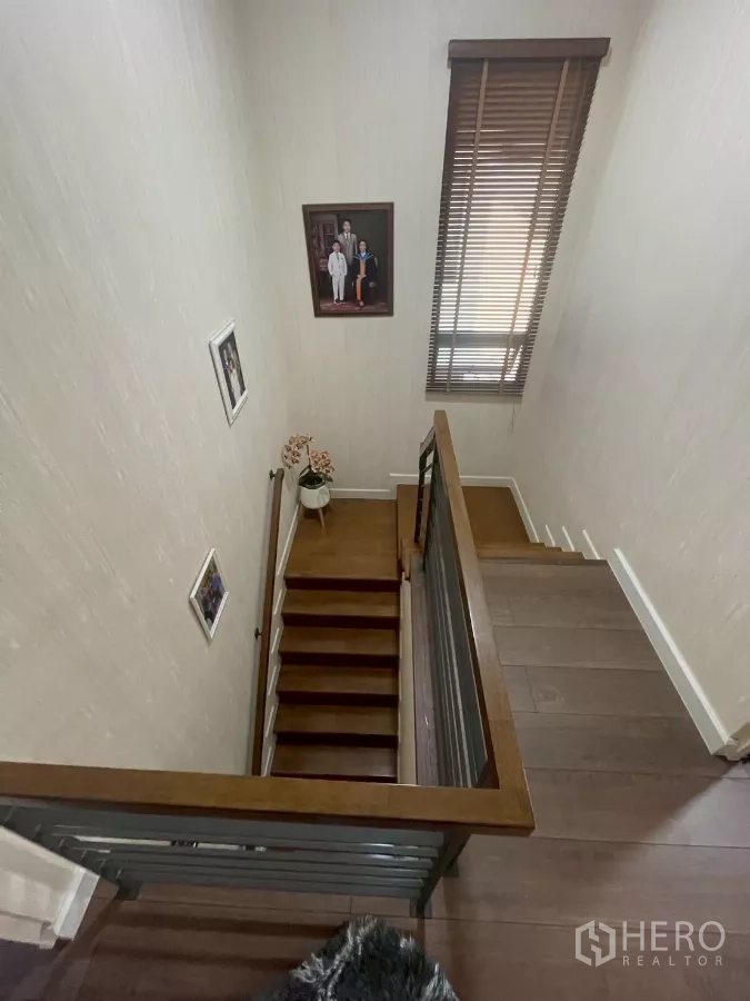Detached House for sale in Bang Phli, Samut Prakan - Wood staircase with handrail and tall window bringing natural light to the landing.