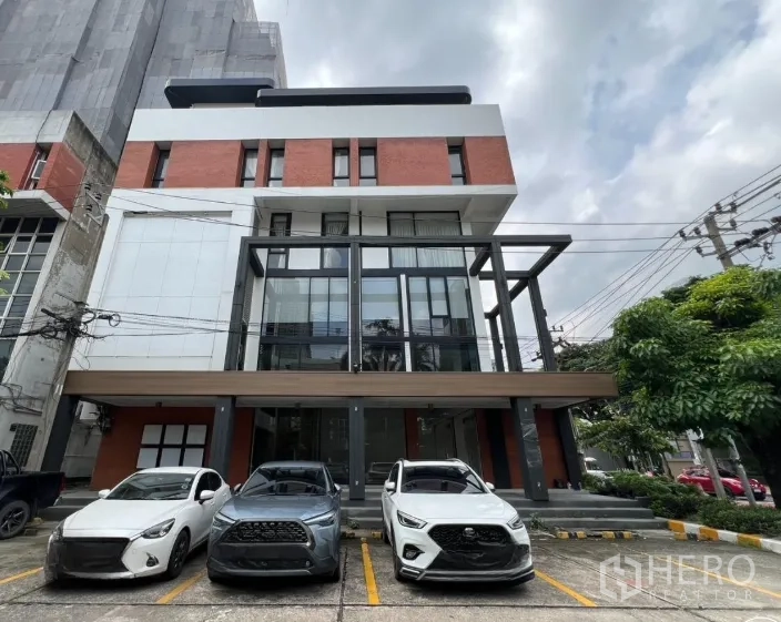 零售空间 出租在Khlong Toei, Bangkok - 现代4.5层玻璃立面商铺建筑，前方有停车位