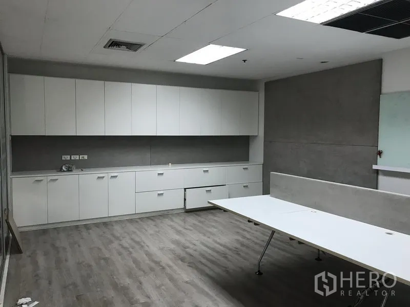 零售空间 出租在Pathum Wan, Bangkok - 开放式办公区，长排白色柜体、工作台和LED照明。