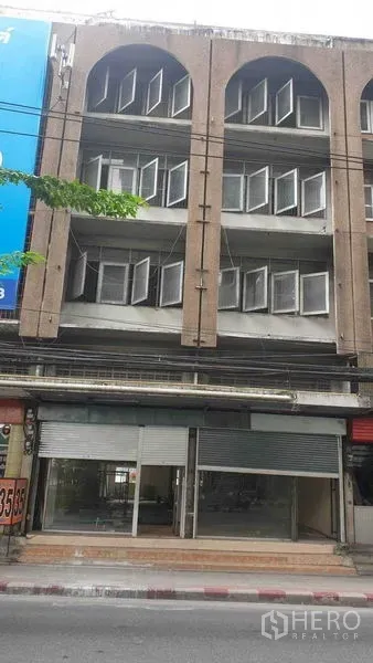 店屋 出租在Phra Khanong, Bangkok - 四层店屋外立面，拱形窗与卷闸门店面。