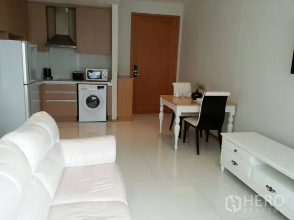 คอนโด ให้เช่าในKhlong Toei, Bangkok - ห้องนั่งเล่นแบบเปิดโล่งพร้อมโซฟาสีขาว ครัวบิลท์อิน มีเครื่องซักผ้าและโต๊ะทานข้าว ในคอนโดย่านสุขุมวิท