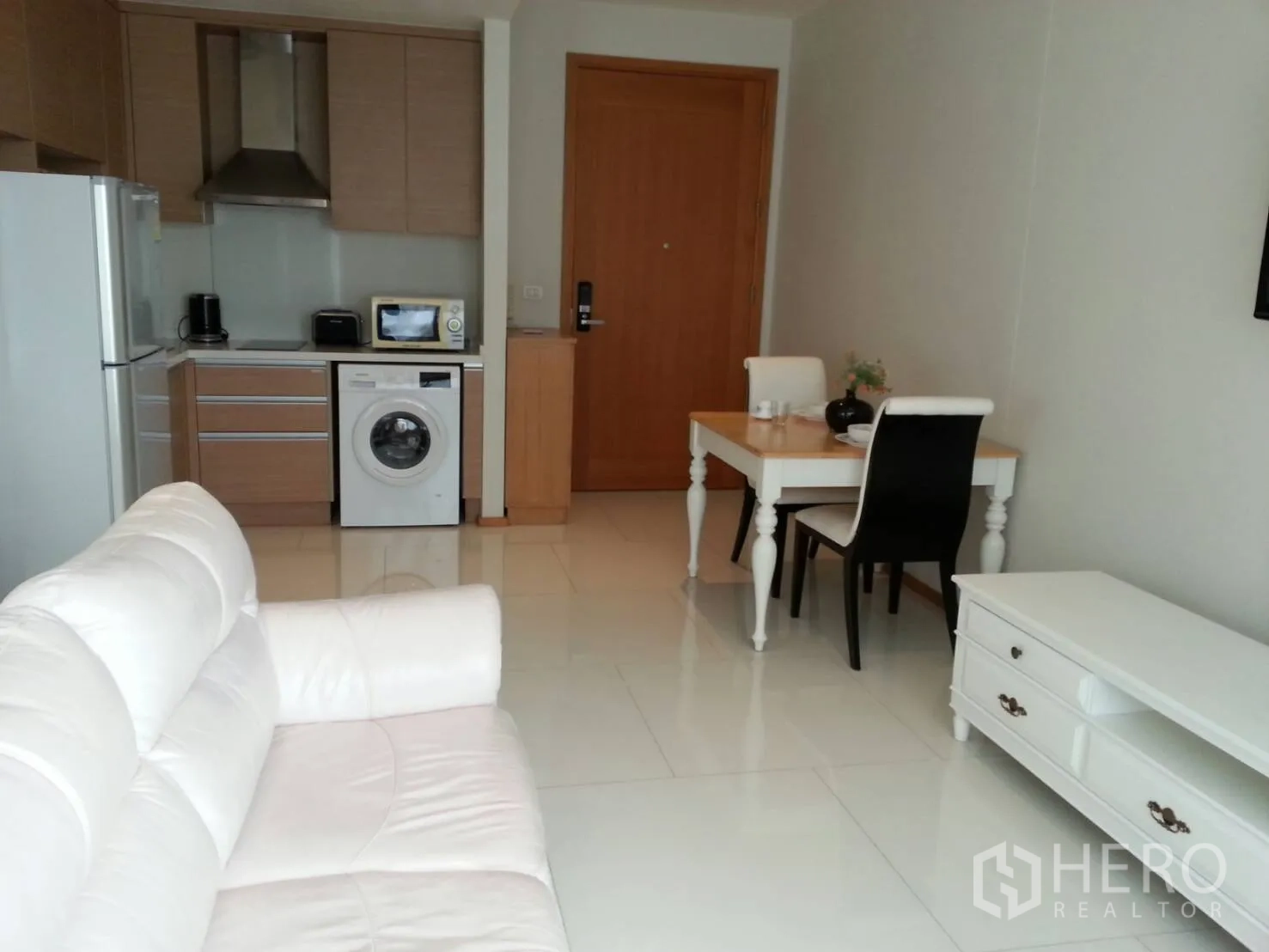 คอนโด ให้เช่าในKhlong Toei, Bangkok - ห้องนั่งเล่นแบบเปิดโล่งพร้อมโซฟาสีขาว ครัวบิลท์อิน มีเครื่องซักผ้าและโต๊ะทานข้าว ในคอนโดย่านสุขุมวิท