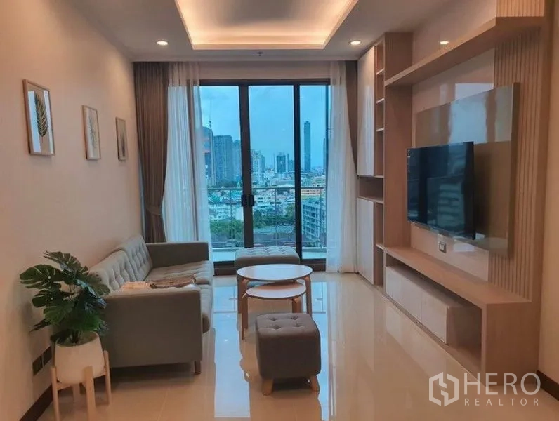 คอนโด ให้เช่าในWatthana, Bangkok - ห้องนั่งเล่นสว่างพร้อมผนังทีวีบิวท์อิน ชุดโซฟา และหน้าต่างสูงจรดเพดานมองเห็นวิวเมืองกรุงเทพฯ