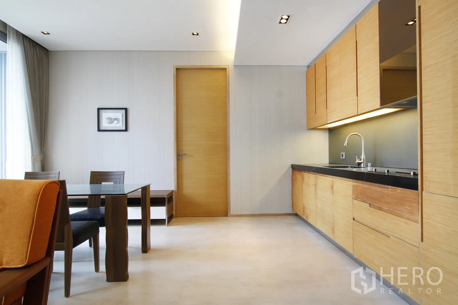 คอนโด ขายในBang Rak, Bangkok - พื้นที่นั่งเล่นแบบเปิดพร้อมโต๊ะอาหารกระจกและครัวบิลท์อินไม้ท็อปหินสีดำ