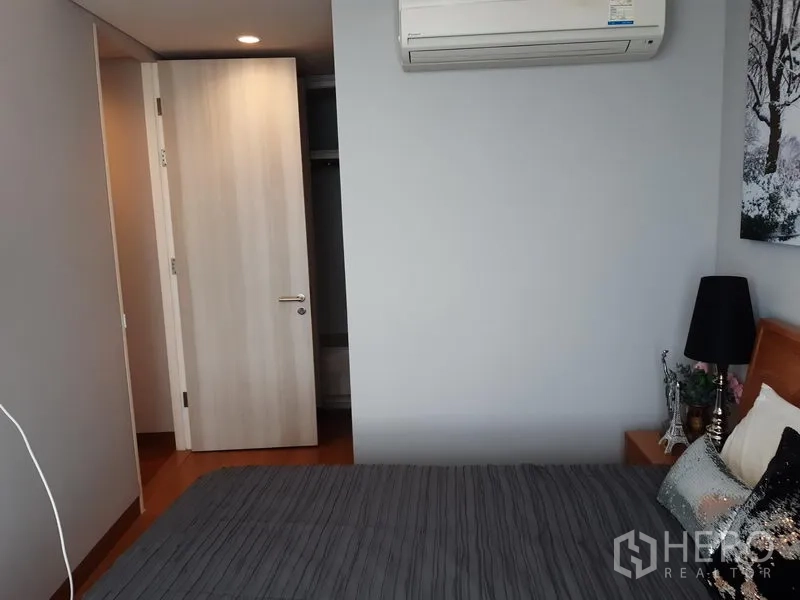 Condominium for rent in Khlong Toei, Bangkok - Bedroom with bed, air-conditioning and access to a closet.