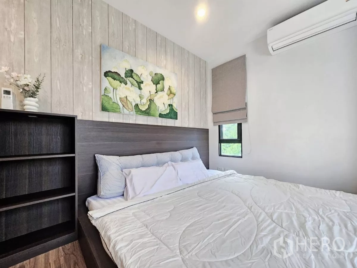 Detached House for rent or sale in Don Mueang, Bangkok - Cozy bedroom with king bed, wood accent wall, and air conditioning.