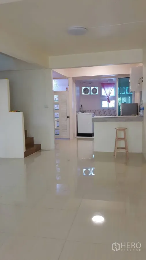 ทาวน์เฮาส์ ให้เช่าในKhlong Toei, Bangkok - พื้นที่นั่งเล่นแบบเปิด พื้นกระเบื้องมันวาว มีบันได และมุมครัวพร้อมเคาน์เตอร์บาร์