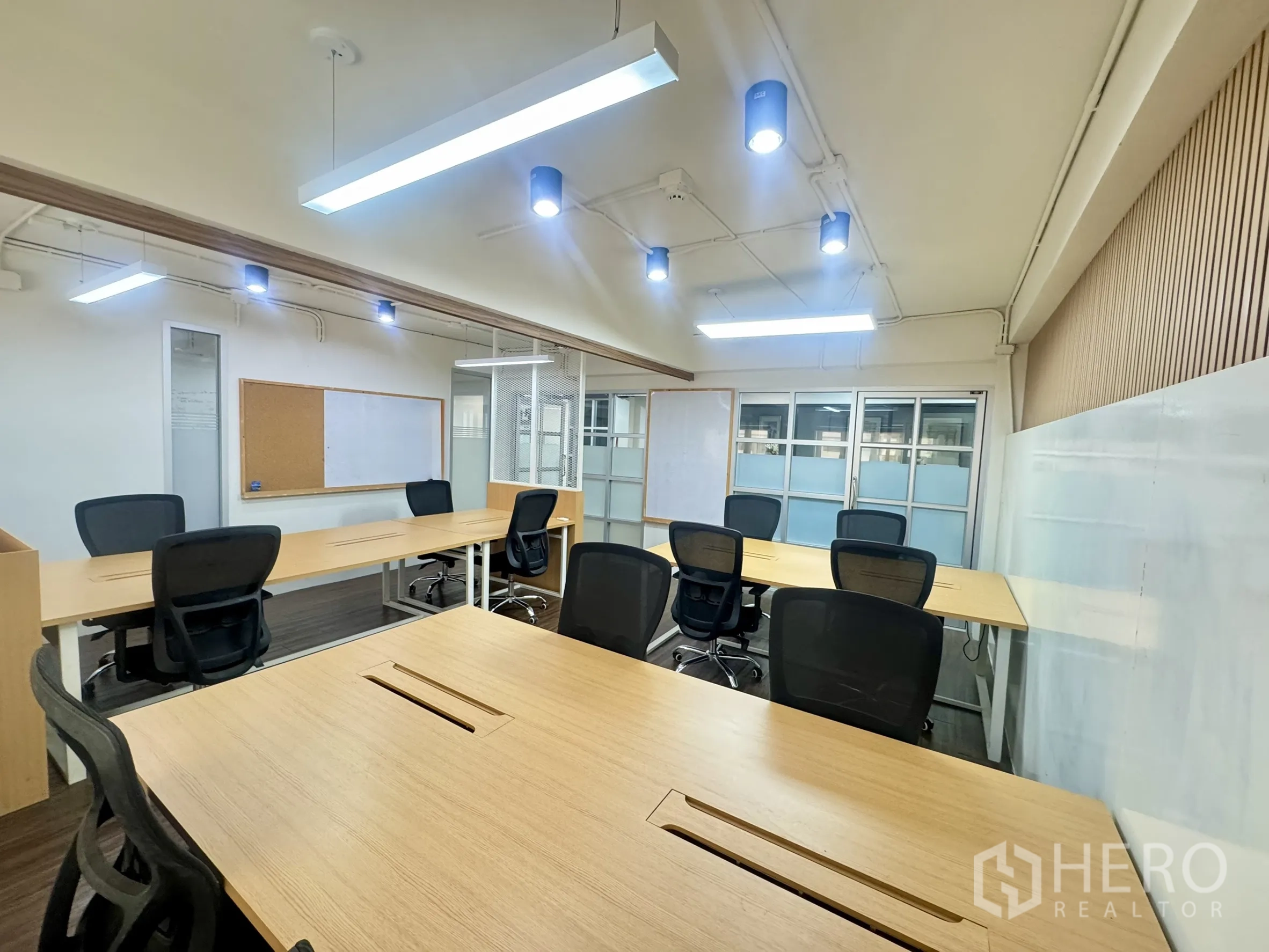 Office Space for rent in Bang Rak, Bangkok - Bright workspace with multiple long desks, pinboards and whiteboards, and glass partitions.