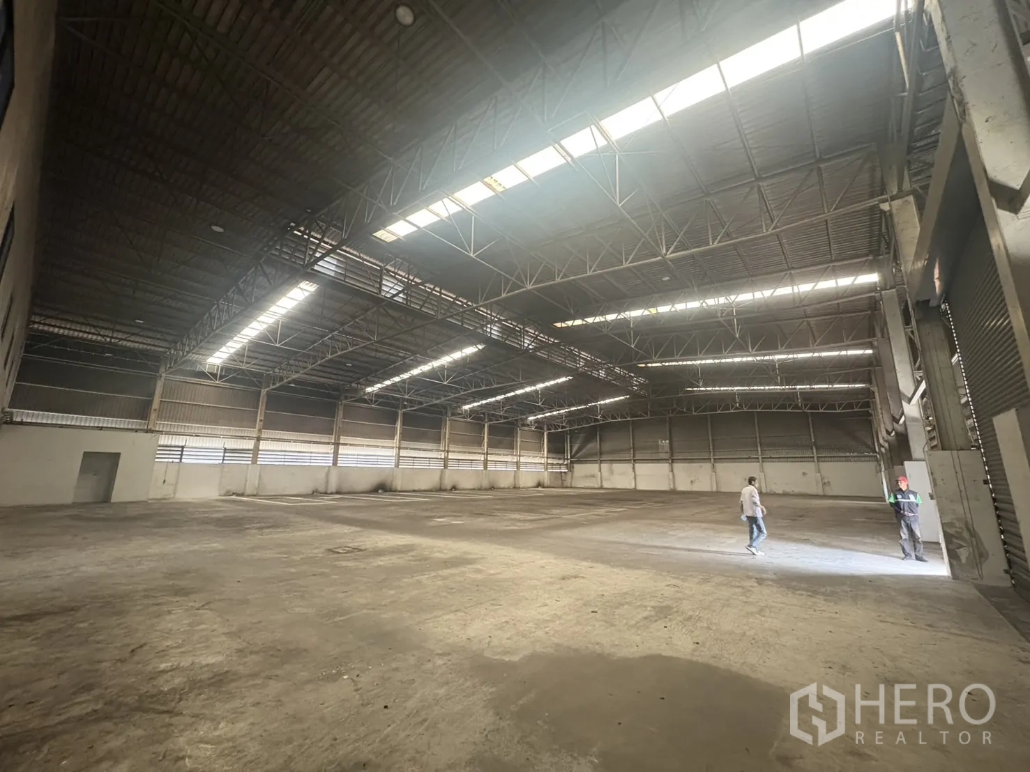 Factory for rent or sale in Samut Prakan - Front office entrance with canopy and lined parking bays.