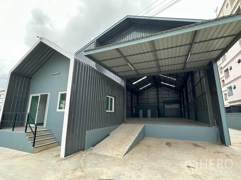 Factory for rent in Khlong Luang, Pathum Thani - Close view of loading platform and ramp beside the office entrance with steps.