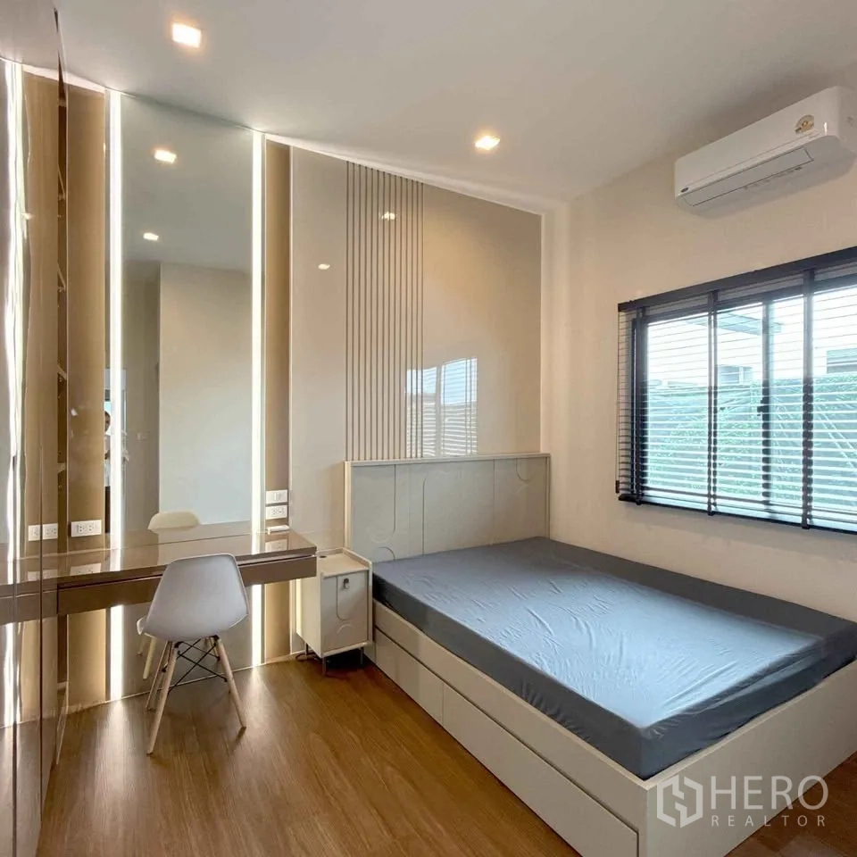 Detached House for rent in Bang Phli, Samut Prakan - Bright bedroom with built-in desk, mirror lighting, bed and window blinds.