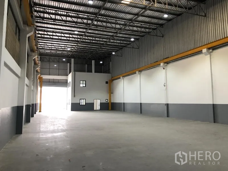 工厂 出租或出售在Bang Phli, Samut Prakan - 开阔厂房面对前部卷帘门，内有夹层式办公室模块。