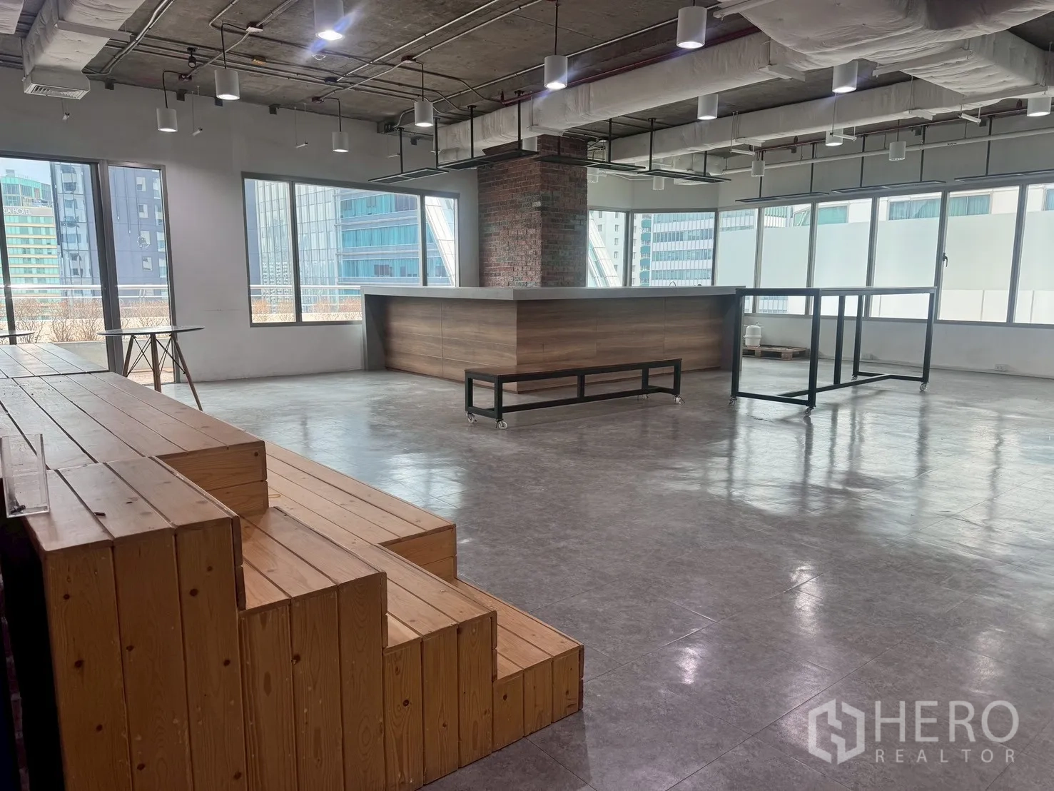 办公室 for rent in Watthana, Bangkok - 公共区设木质阶梯看台与长吧台，临窗采光佳。