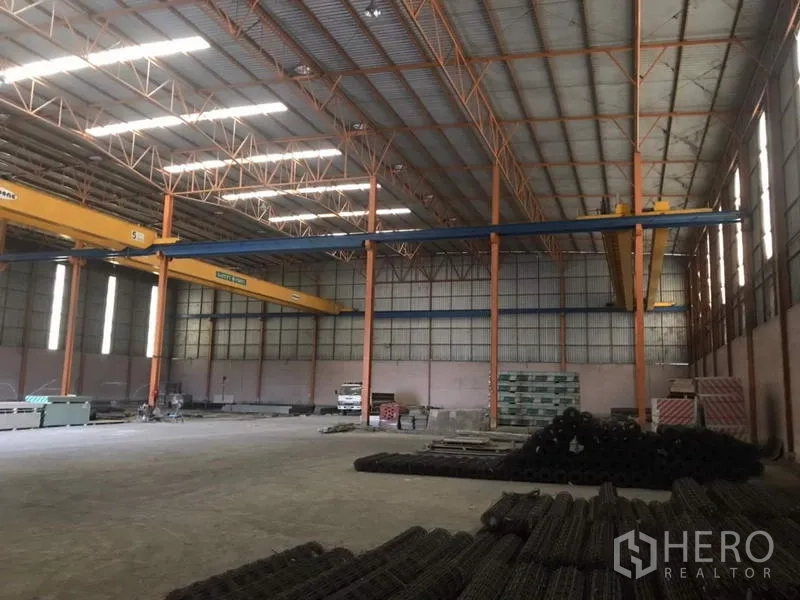 Home Office for sale in Khlong Luang, Pathum Thani - Warehouse storage area with stacked materials and cranes spanning the bay.