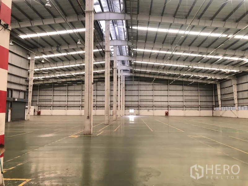 工厂 出租在Phra Nakhon Si Ayutthaya - 宽阔厂房地面，钢结构高屋顶，天窗与标线清晰，适合生产仓储。