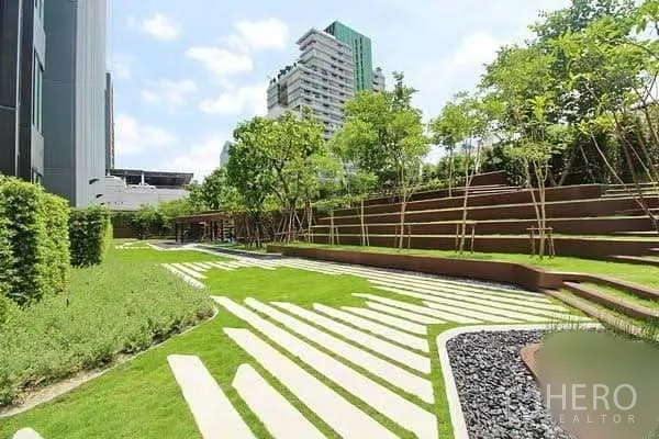 Condominium for sale in Bang Rak, Bangkok - Landscaped outdoor garden with tiered lawns, trees and modern high‑rise buildings in the background.
