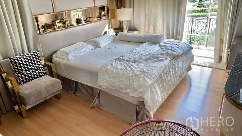 บ้าน ให้เช่าหรือขายในBueng Kum, Bangkok - ห้องนอนมาสเตอร์ เตียงคิงส์ไซส์ พื้นไม้ และประตูระเบียงมองเห็นสวน