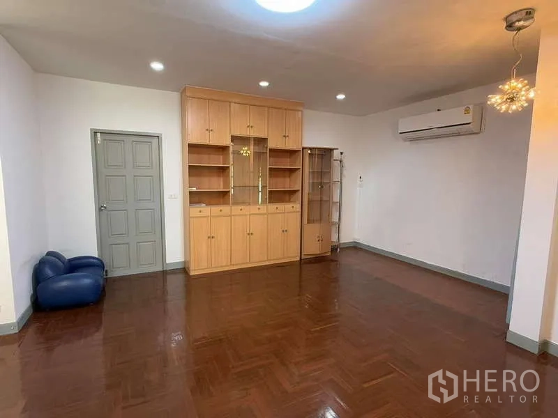 Detached House for rent in Bang Kapi, Bangkok - Large living area with display cabinet and air conditioning unit.