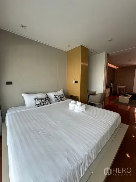 อพาร์ทเมนท์ ให้เช่าในKhlong Toei, Bangkok - ห้องนอนสว่าง เตียงคิงไซส์ พื้นไม้ และผนังหัวเตียงโทนอ่อน