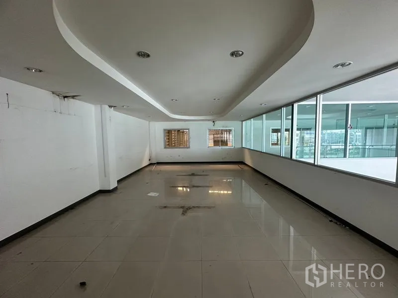 Showroom for rent or sale in Lam Luk Ka, Pathum Thani - Long office space with recessed ceiling and side windows.