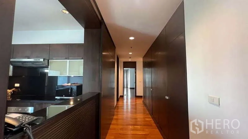 อพาร์ทเมนท์ ให้เช่าในPathum Wan, Bangkok - ทางเดินยาวข้างครัวพร้อมตู้บิลท์อินสีเข้มและพื้นไม้