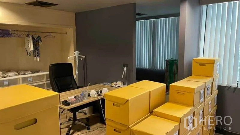 สำนักงาน ให้เช่าในKhlong Toei, Bangkok - ห้องเก็บของและบรรจุภัณฑ์ มีกล่องสีเหลืองเรียงข้างโต๊ะทำงาน