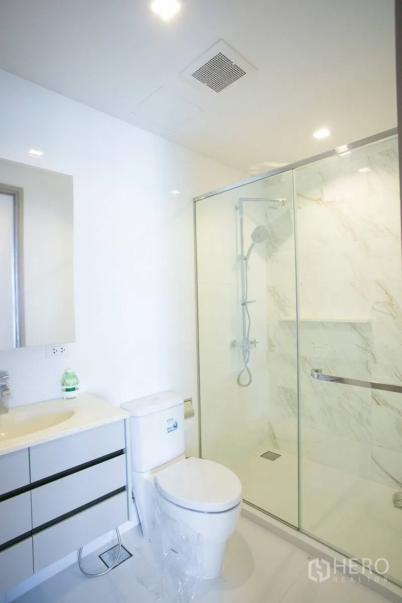 คอนโด ให้เช่าในWatthana, Bangkok - ห้องน้ำโทนขาวสะอาด มีตู้กระจกกั้นอาบน้ำ อ่างล้างหน้า และชักโครก