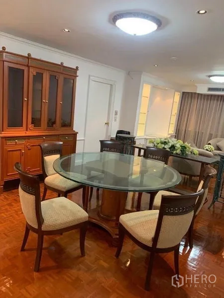 คอนโด ขายในWatthana, Bangkok - มุมรับประทานอาหาร โต๊ะกระจกกลม เก้าอี้บุผ้า 6 ที่นั่ง ข้างตู้โชว์ไม้