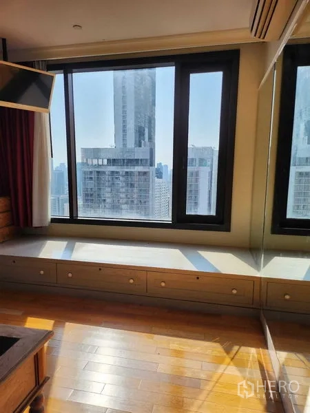 Condominium for sale in Khlong Toei, Bangkok - Corner window seat with built-in drawers and cityscape views.