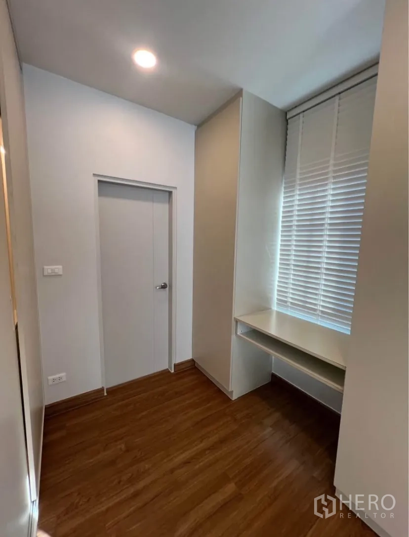 Detached House for rent in Bang Phli, Samut Prakan - Compact study nook with built-in desk, storage and window blinds over a wood floor.