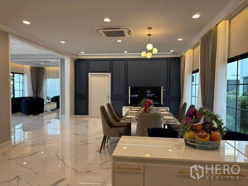 Detached House for rent in Bang Phli, Samut Prakan - Elegant dining room for eight with marble-look floors and a dark feature wall with TV.