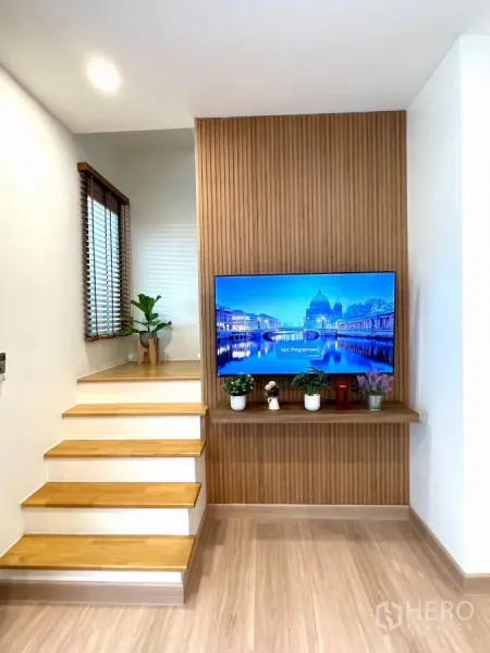 ทาวน์เฮาส์ ให้เช่าในBang Phli, Samut Prakan - บันไดไม้พร้อมผนังลายซี่ไม้ ติดตั้งทีวีและตกแต่งต้นไม้