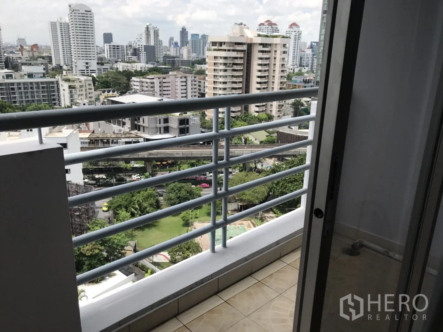 公寓 出租在Khlong Toei, Bangkok - 小阳台带栏杆，俯瞰城市与下方泳池。