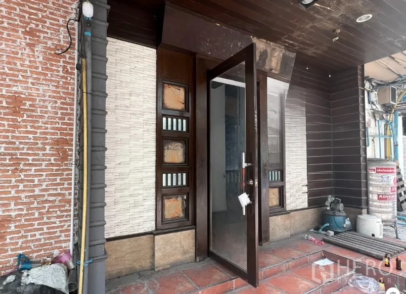 พื้นที่ขายปลีก ให้เช่าในKhlong Toei, Bangkok - ทางเข้าหลัก ประตูกระจก กรอบไม้ ขั้นบันไดปูกระเบื้อง ข้างผนังอิฐโชว์