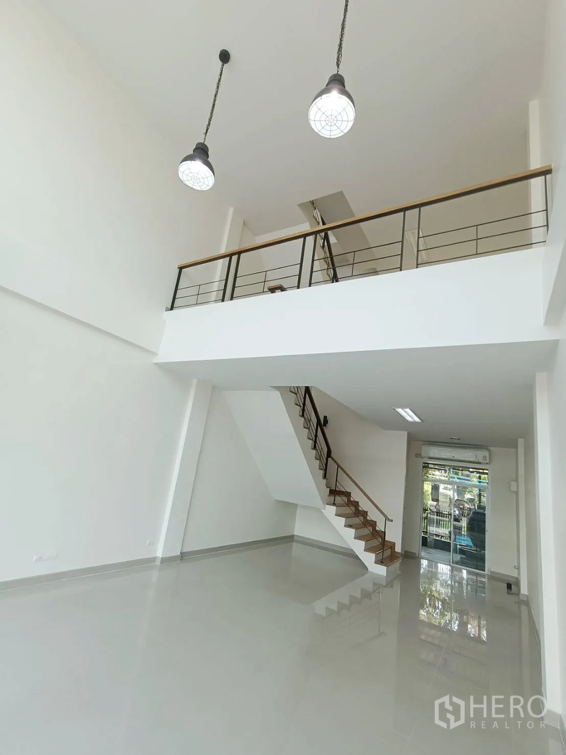 สำนักงานที่บ้าน for rent or sale in Prawet, Bangkok - ชั้นล่างเพดานสูงพร้อมชั้นลอย โคมไฟห้อย บันได และประตูกระจกหน้าอาคาร