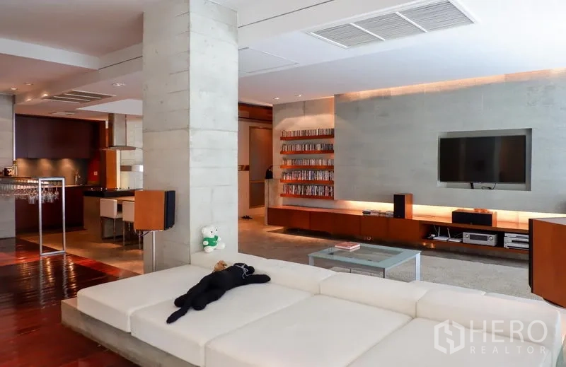 คอนโด ให้เช่าหรือขายในKhlong Toei, Bangkok - ห้องนั่งเล่นร่วมสมัย โซฟาขนาดใหญ่และผนังทีวีบิวท์อิน เชื่อมต่อครัวเปิด.