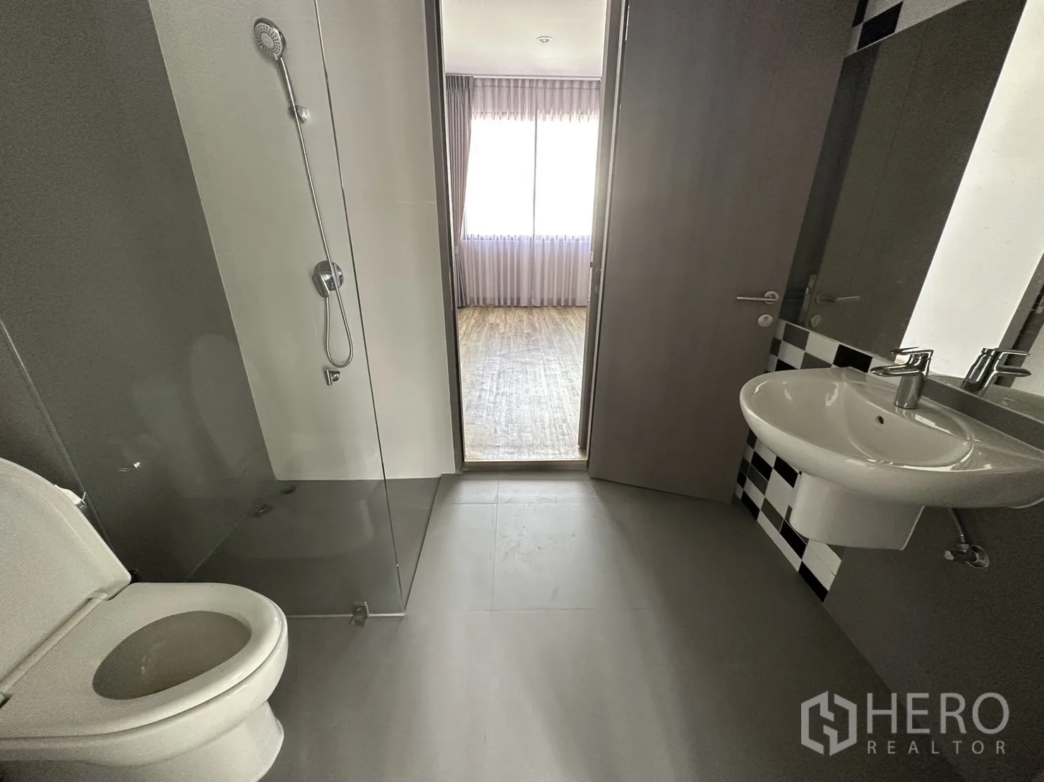 带办公室的家 出租或出售在Suan Luang, Bangkok - 浴室配玻璃淋浴隔断、立柱盆与棋盘格装饰墙面。