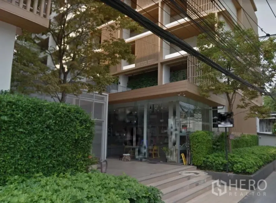 พื้นที่ขายปลีก ให้เช่าในWatthana, Bangkok - ภายนอกอาคารสไตล์โมเดิร์น พร้อมมุมร้านกระจกและแนวพุ่มไม้เขียว