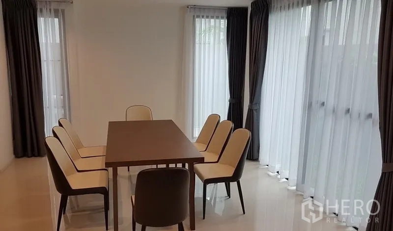 独立式住宅 出租在Prawet, Bangkok - 六人餐厅，落地窗旁配套餐椅与亮面地砖。