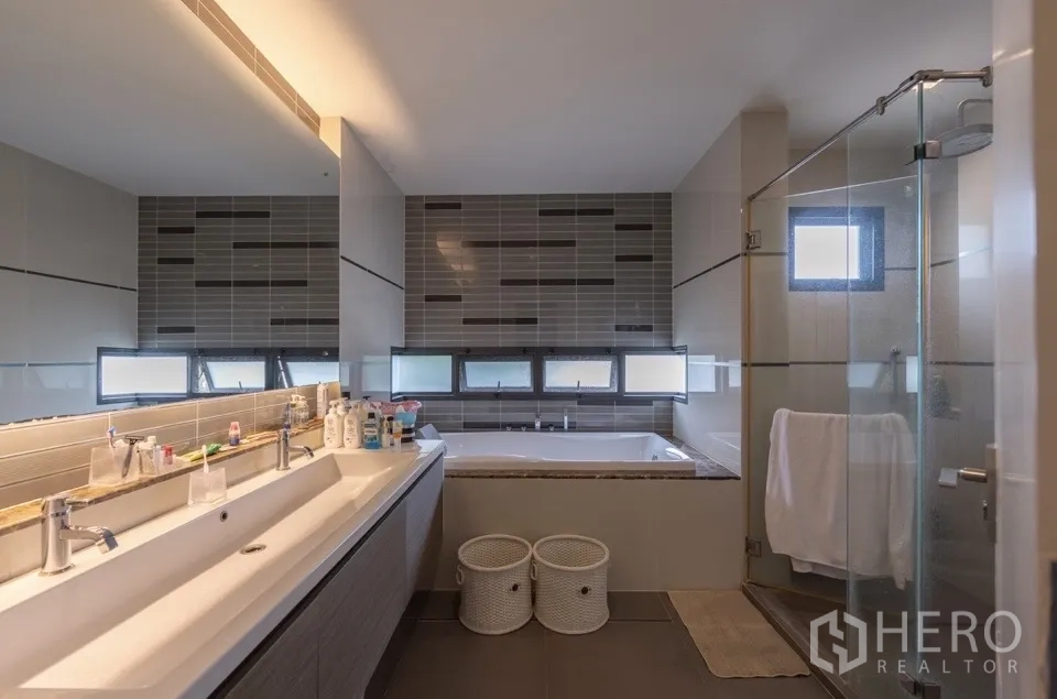 Detached House for rent or sale in Bang Kapi, Bangkok - Main bathroom with double sinks, bathtub, and shower enclosure.