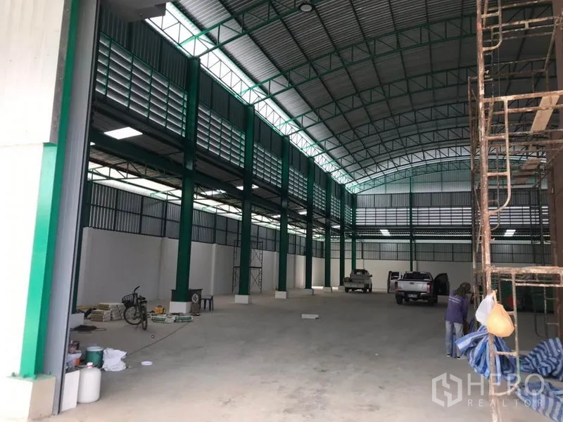 工厂 出租或出售在Mueang Samut Sakhon, Samut Sakhon - 仓库长廊视角，通风百叶与绿色钢柱清晰可见。