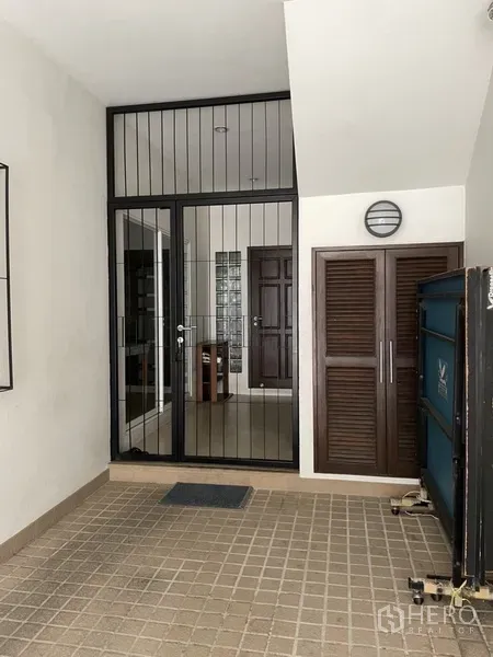 Home Office for rent or sale in Phra Khanong, Bangkok - Secure glass door with black metal bars and storage cabinets at the entrance.
