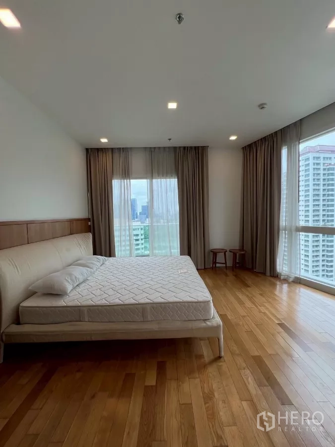 公寓 出租在Khlong Toei, Bangkok - 宽敞主卧，大床、窗帘与环绕式窗户。