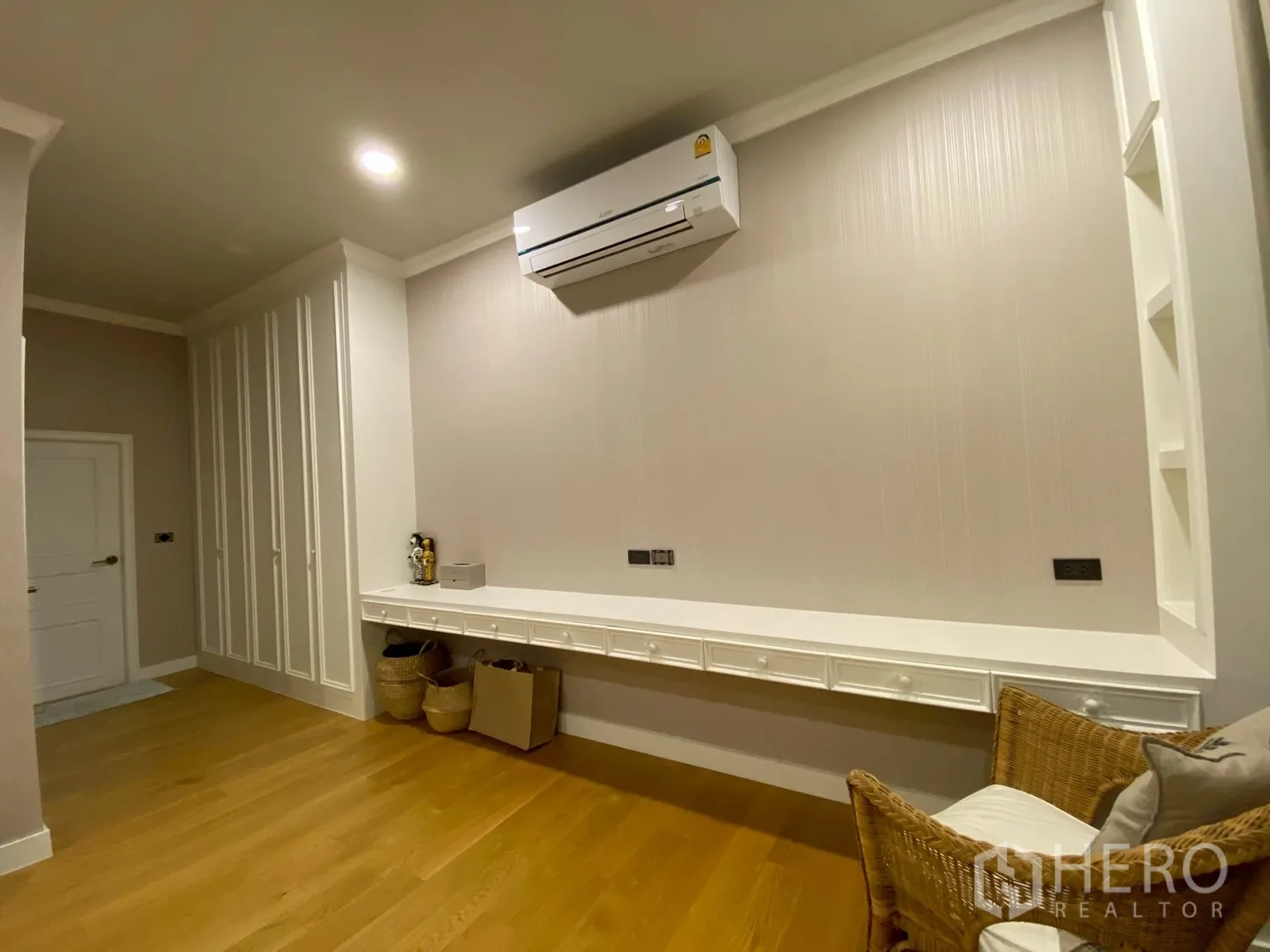Detached House for sale in Mueang Nakhon Pathom, Nakhon Pathom - Corner view with a full-length built-in desk, storage cabinets and a wicker chair.