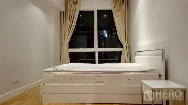 คอนโด ให้เช่าหรือขายในKhlong Toei, Bangkok - ห้องนอนหลักสไตล์มินิมอล มีหน้าต่างบานใหญ่ ผ้าม่าน เตียงควีน และโต๊ะข้าง เต็มอิ่มวิวเมือง