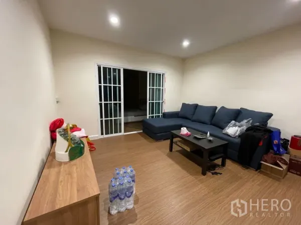 ทาวน์เฮาส์ ให้เช่าในPhra Khanong, Bangkok - ห้องนั่งเล่นอบอุ่น โซฟารูปตัวแอล โต๊ะกลาง และประตูกระจกบานเลื่อน