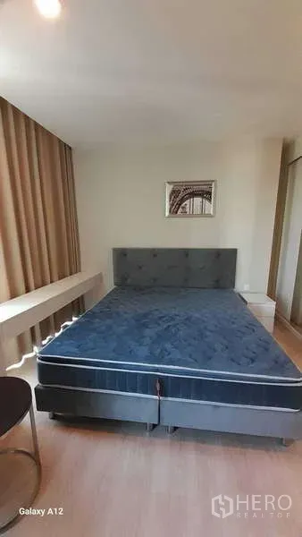 Condominium for rent - Master bedroom with large upholstered bed and wood floors